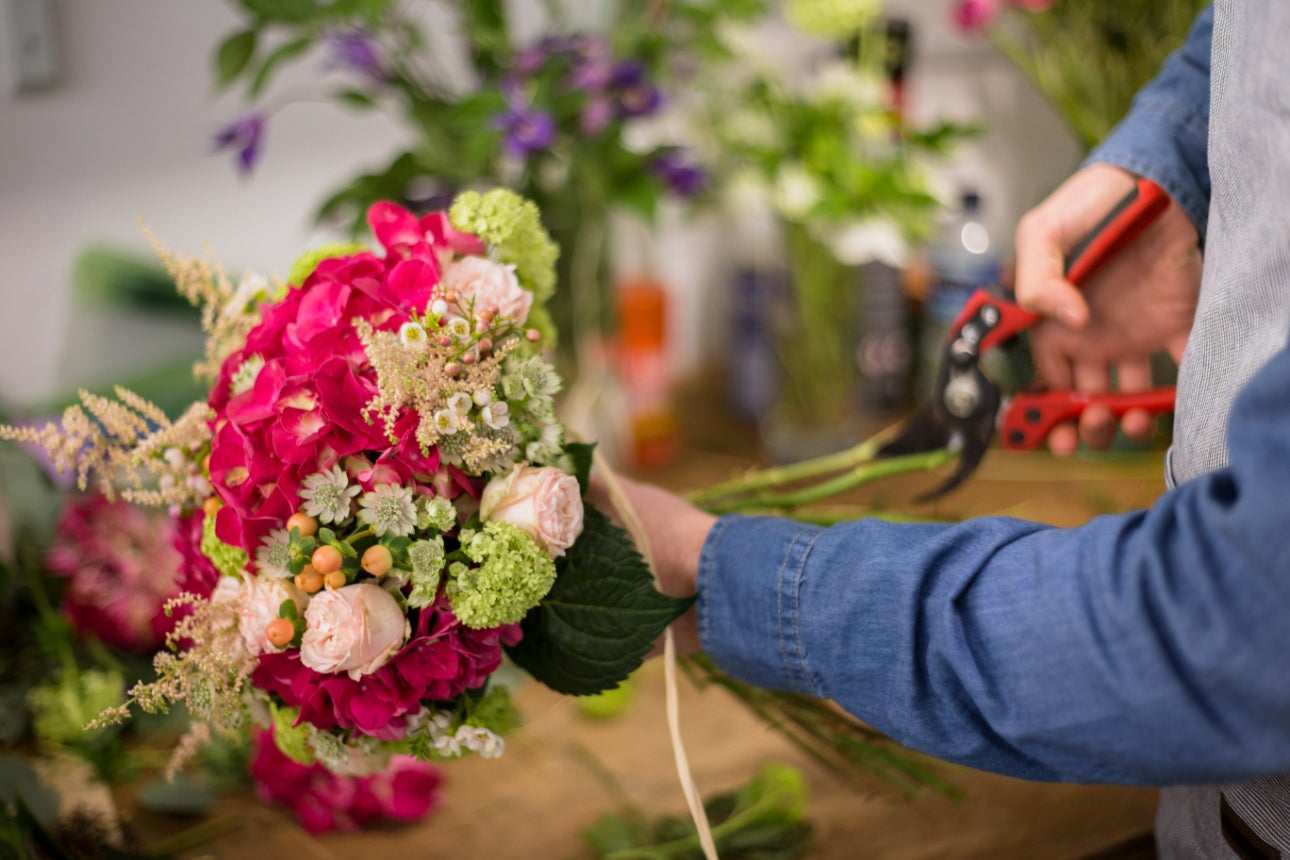 Fleuriste prépare un bouquet de fleurs dans sa boutique parisienne 